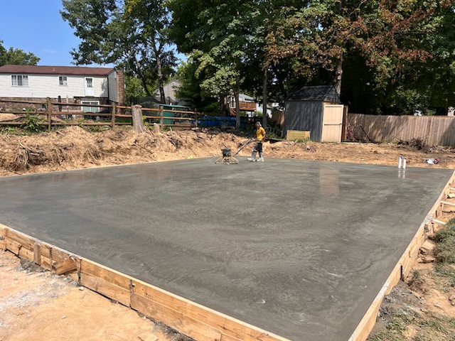 Crew power-troweling a freshly poured concrete slab to a smooth finish